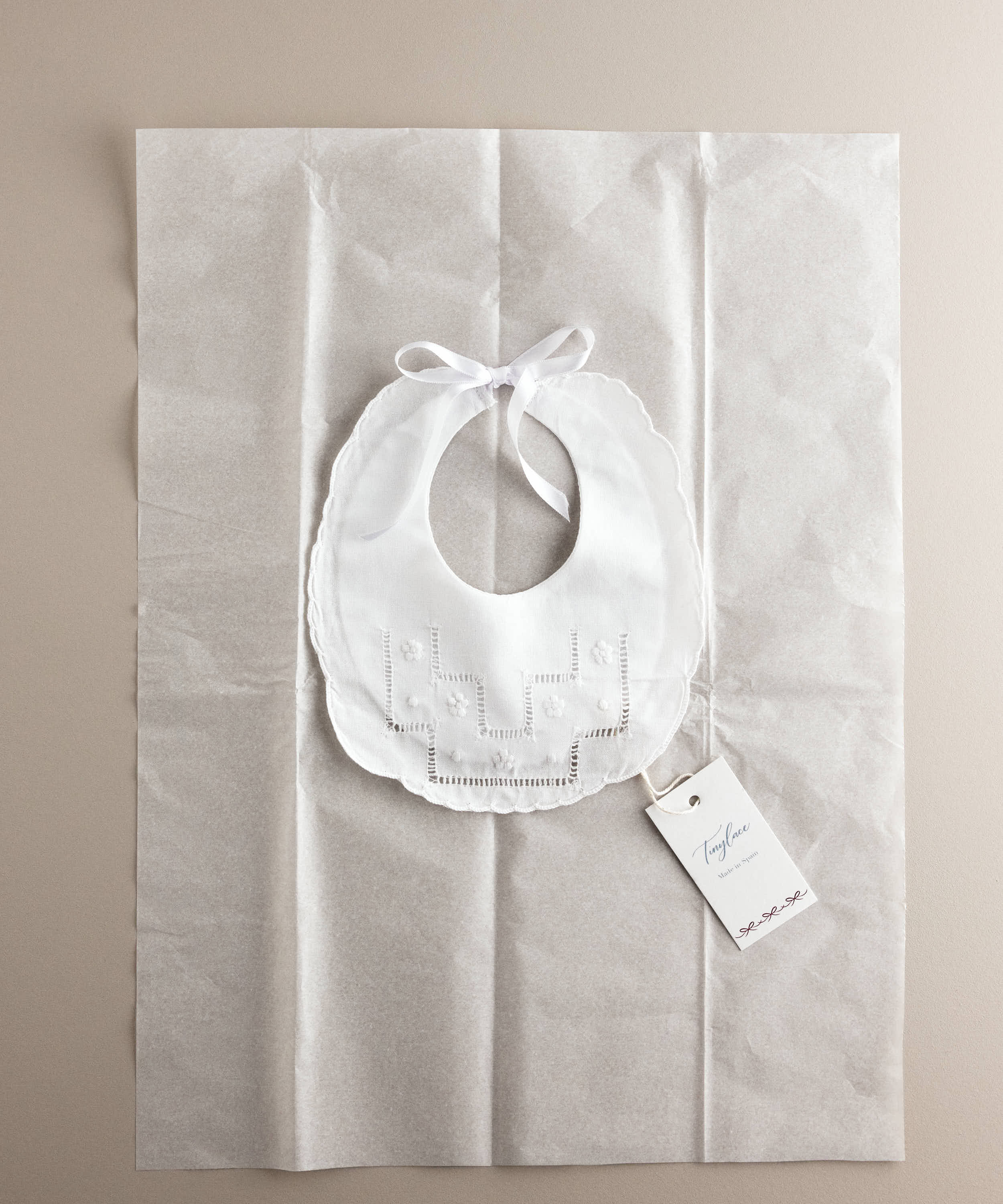 Babero de bebé de lino con vainica en su envoltorio, ideal como regalo de nacimiento — Tinylace
