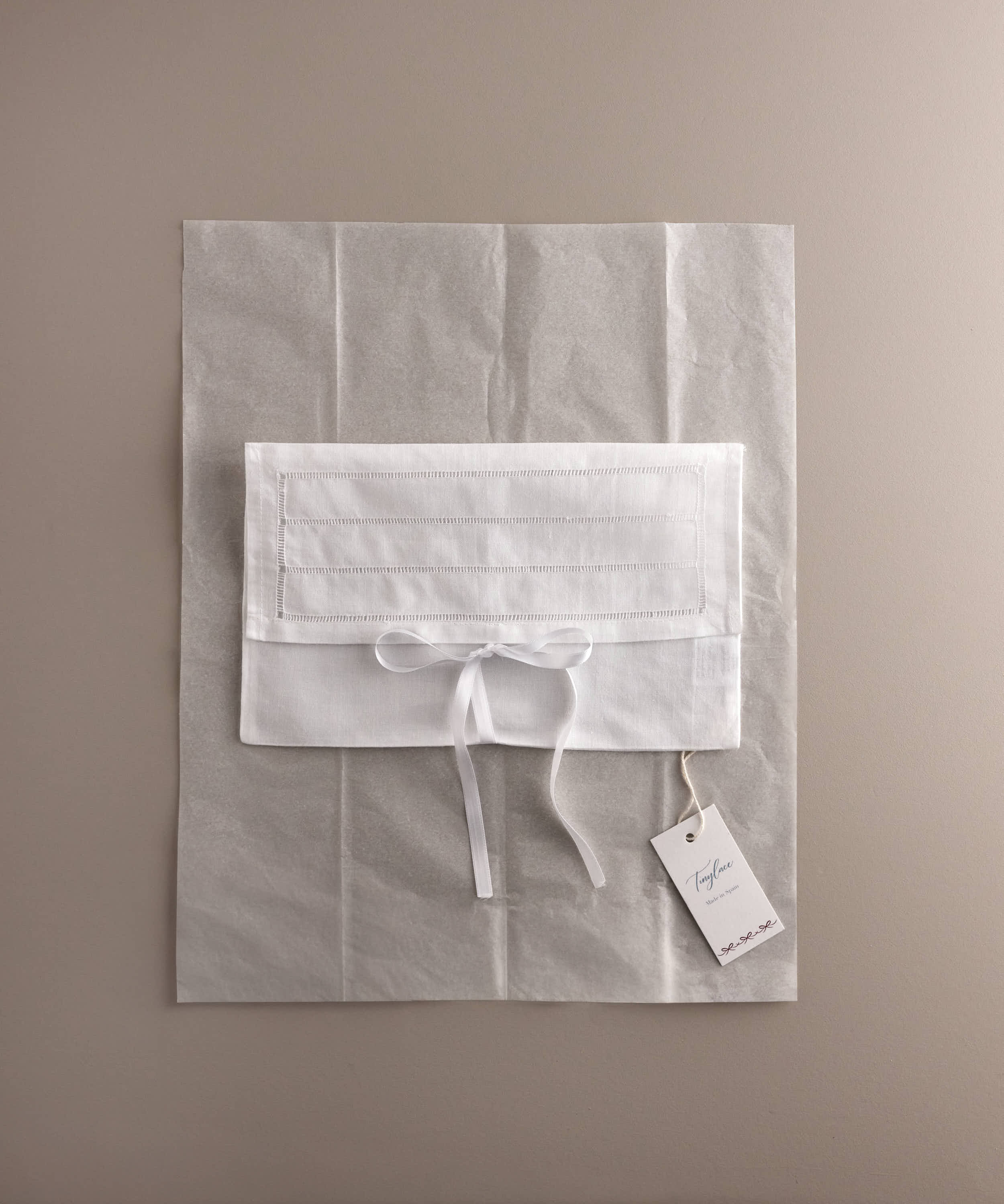 Bolsa de lino Tinylace sobre papel de seda con etiqueta de marca.
