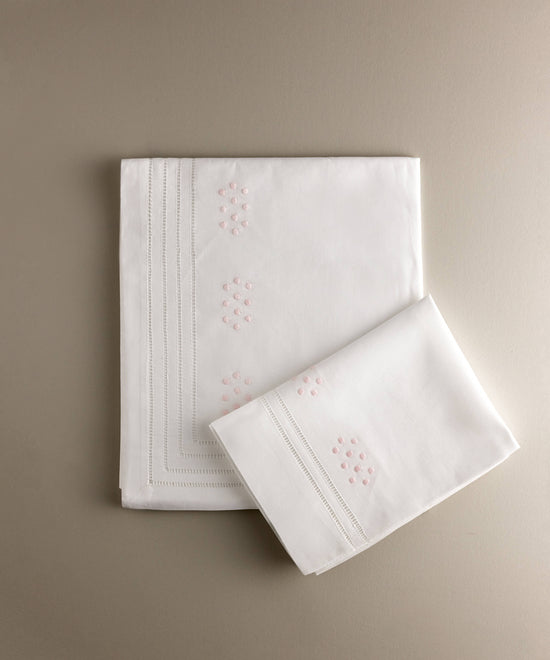 Juego de sábanas de cuna de algodón blanco, encimera y funda de almohada con bodoques bordados a mano en rosa y vainica, de Tinylace.