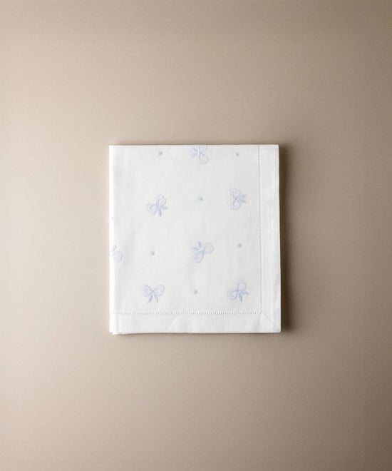 Sábana encimera de minicuna de algodón con lazos bordados en azul celeste y vainica