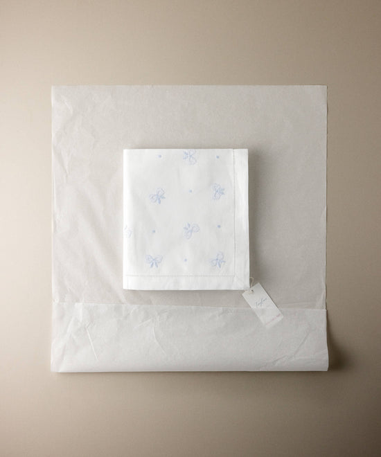 uego de sábanas de minicuna Tinylace con etiqueta, envuelto en papel de regalo
