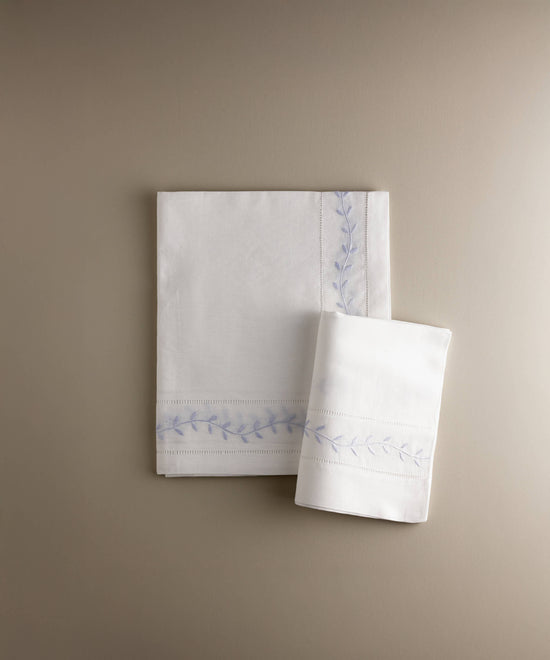 Juego de sábana encimera y funda de almohada de cuna con hojas bordadas en azul, confeccionado artesanalmente en España — Tinylace
